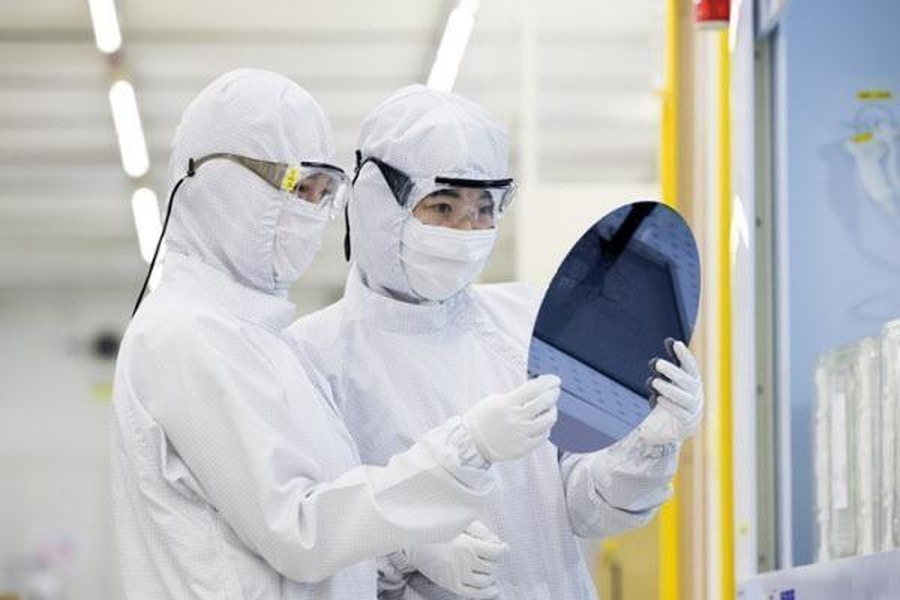 クリーンルームでシリコンウェハを検査する半導体エンジニア